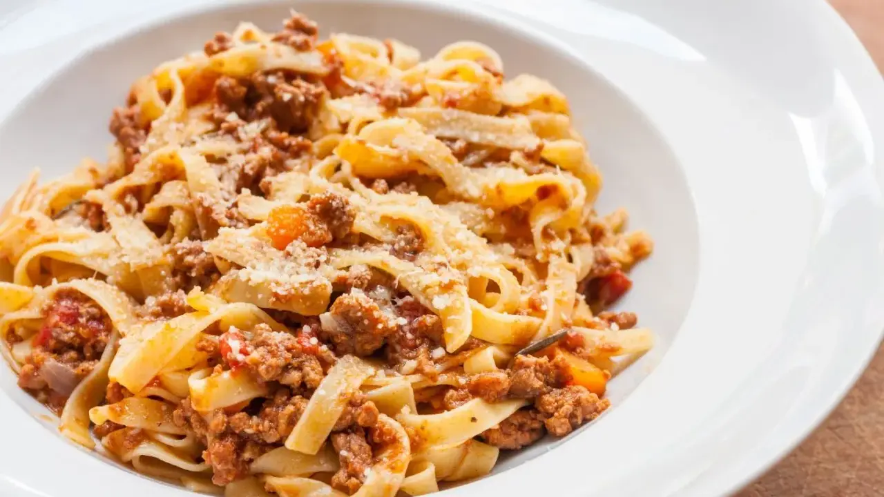 Pyszne tagliatelle z bogatym sosem mięsnym, posypane parmezanem. Idealny spaghetti bolognese przepis oryginalny na obiad.