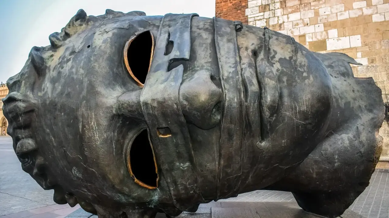 Monumentalna rzeźba głowy na Rynku Głównym w Krakowie. Jedna z wielu ciekawostek o Krakowie, która przyciąga wzrok turystów.