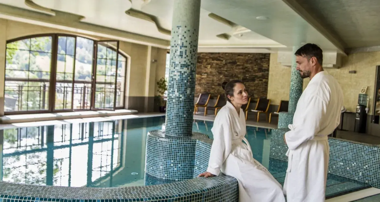 Para w szlafrokach przy basenie. Hotel Elbrus Spa & Wellness – opinie potwierdzają relaks.
