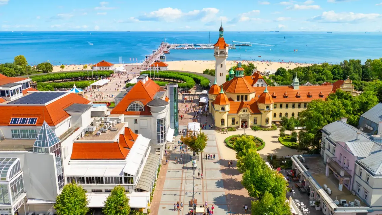 Malownicze miejscowosci nad morzem z molo, plażą i zabytkową architekturą.