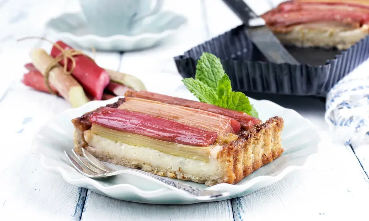 Pyszna tarta z rabarbarem, która pokazuje, co można zrobić z rabarbaru. Podana na talerzyku z widelcem.
