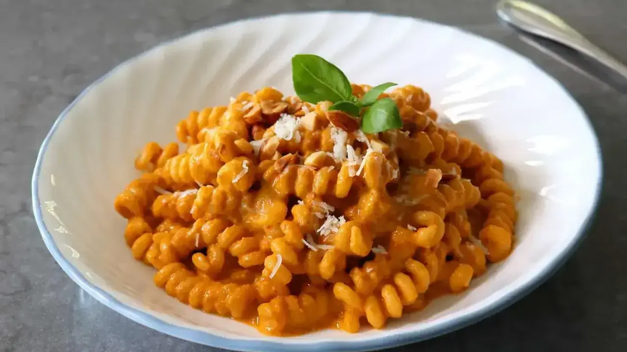 Pyszny makaron fusilli w kremowym sosie pomidorowym, posypany parmezanem i orzeszkami. Idealny makaron na obiad.