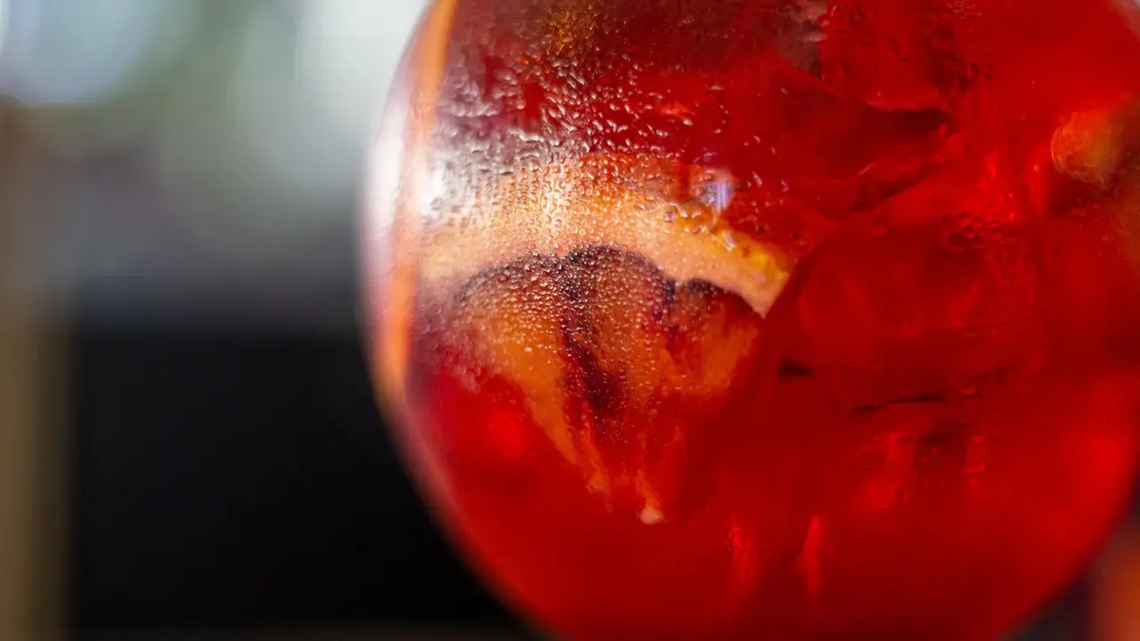 Orzeźwiający Martini Fiero drink z lodem i plasterkiem pomarańczy, skraplający się od zimna.