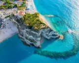 Widok z lotu ptaka na skaliste klify i piaszczyste plaże Kalabrii, z turkusową wodą Morza Śródziemnego.