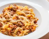 Pyszne tagliatelle z bogatym sosem mięsnym, posypane parmezanem. Idealny spaghetti bolognese przepis oryginalny na obiad.
