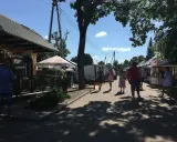 Spacer po targu w upalny dzień. Ludzie oglądają stoiska, szukając lokalnych produktów i pamiątek. Tleń atrakcje oferują wiele możliwości spędzenia wolnego czasu.