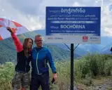 Para podróżników z flagą Gruzji w Bochorna, najwyżej położonej osadzie w Europie. Odpowiedź na pytanie: czy w Gruzji jest bezpiecznie? Tak!