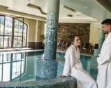 Para w szlafrokach przy basenie. Hotel Elbrus Spa & Wellness – opinie potwierdzają relaks.