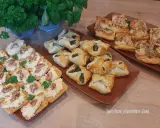 Na stole trzy rodzaje przekąsek: krakersy z pastą serową i orzechami, pieczone ciastka z nadzieniem szpinakowym i kwadratowe tartaletki z farszem. Idealna szybka przekąska na imprezę.