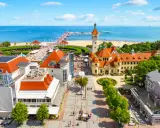 Malownicze miejscowosci nad morzem z molo, plażą i zabytkową architekturą.