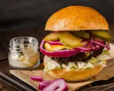 Pyszny burger z soczystą wołowiną, chrupiącą sałatą, piklami, czerwoną cebulą i majonezem. Idealny na prawdziwe burgery przepis.