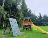 Kolorowy plac zabaw w Polańczyku: ścianka wspinaczkowa, domek ze zjeżdżalnią i huśtawki. Idealne polańczyk atrakcje dla dzieci.
