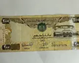 Banknot 200 dirhamów, waluta w Dubaju, z wizerunkiem sokoła i budynków.