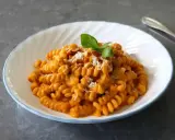 Pyszny makaron fusilli w kremowym sosie pomidorowym, posypany parmezanem i orzeszkami. Idealny makaron na obiad.