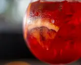 Orzeźwiający Martini Fiero drink z lodem i plasterkiem pomarańczy, skraplający się od zimna.