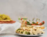 Kolorowe, zdrowe przekąski na imprezę: koreczki z warzywami, jajka faszerowane, roladki z tortilli, winogrona, ser i salami.