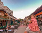 Wiedeń rynek tętni życiem. Dziewczynka na ramionach taty podziwia gwarne uliczki z restauracjami i sklepikami.