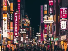 Nocne życie Tokio, neonowe szyldy zapraszają, kiedy do Japonii. Tłumy ludzi spacerują ulicami pełnymi barów i sklepów.