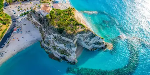 Widok z lotu ptaka na skaliste klify i piaszczyste plaże Kalabrii, z turkusową wodą Morza Śródziemnego.
