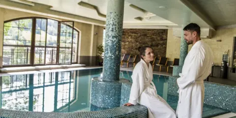 Para w szlafrokach przy basenie. Hotel Elbrus Spa & Wellness – opinie potwierdzają relaks.