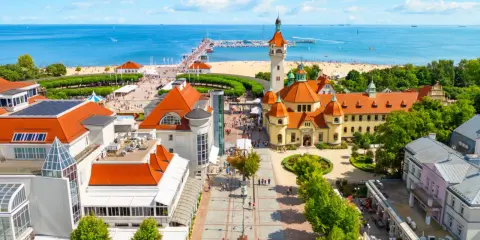 Malownicze miejscowosci nad morzem z molo, plażą i zabytkową architekturą.