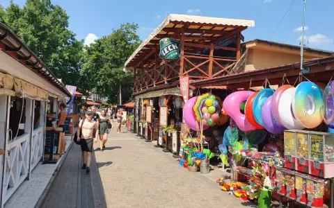 Skorzęcin atrakcje: kolorowe koła do pływania, zabawki plażowe i budki z grami na deptaku.