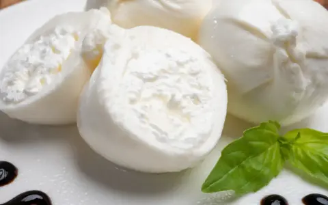 Świeża burrata co to? Delikatny ser z kremowym wnętrzem, podany z bazylią i balsamicznym sosem.