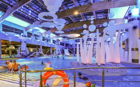 Wesoła zabawa w aquaparku w Sopocie, mnóstwo ludzi cieszy się basenem i atrakcjami. Warto sprawdzić aquapark Sopot opinie przed wizytą.