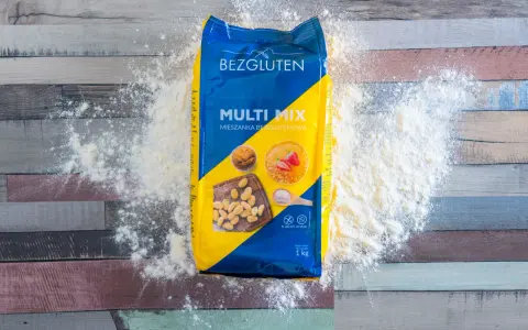 Opakowanie mąki bez glutenu "Multi Mix" rozsypane na drewnianym blacie. Idealna do wypieków dla osób na diecie bezglutenowej.
