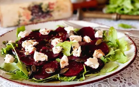 Pyszne carpaccio z buraka z serem feta, rukolą i pestkami dyni na talerzu.