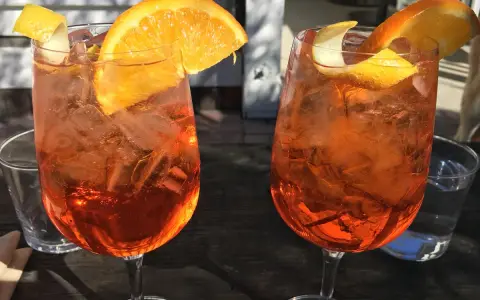Dwa orzeźwiające drinki z pomarańczą i lodem. Idealne na aperitivo, co to jest? To włoska tradycja!
