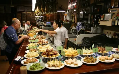Wybór pysznych tapas na barze, ludzie wybierają przekąski.