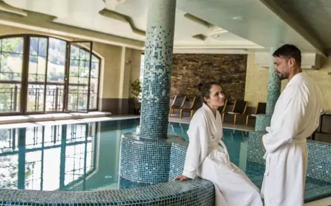 Para w szlafrokach przy basenie. Hotel Elbrus Spa & Wellness – opinie potwierdzają relaks.