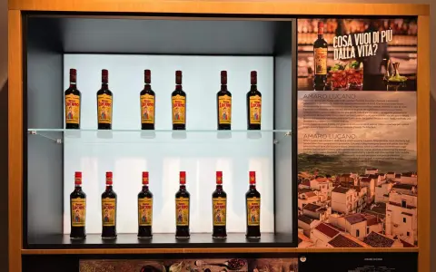 Butelki amaro Lucano stoją na półkach, tworząc elegancką ekspozycję.