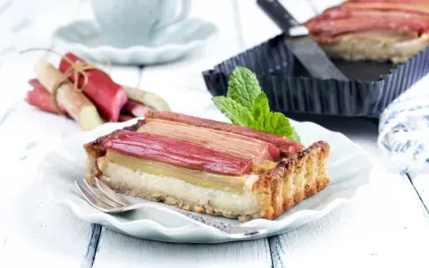 Pyszna tarta z rabarbarem, która pokazuje, co można zrobić z rabarbaru. Podana na talerzyku z widelcem.