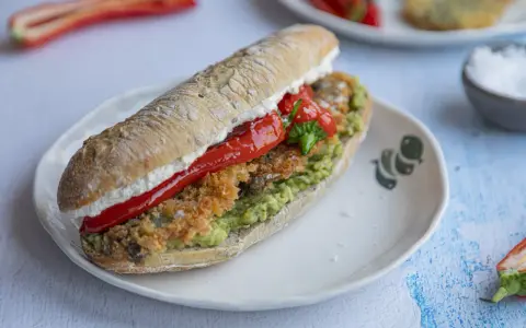 Pyszna kanapka ze śledziem, awokado i pieczoną papryką na chrupiącej bułce. Idealna na szybki lunch.