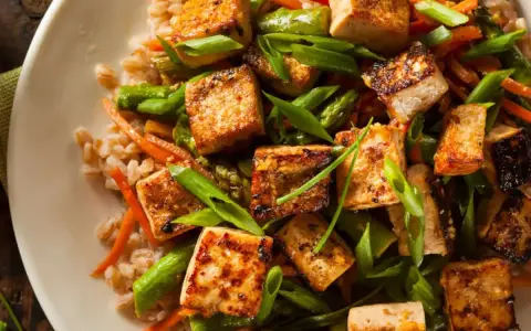 Smażone kostki tofu z warzywami i kaszą. Idealny pomysł, jak przyrządzić tofu na obiad.