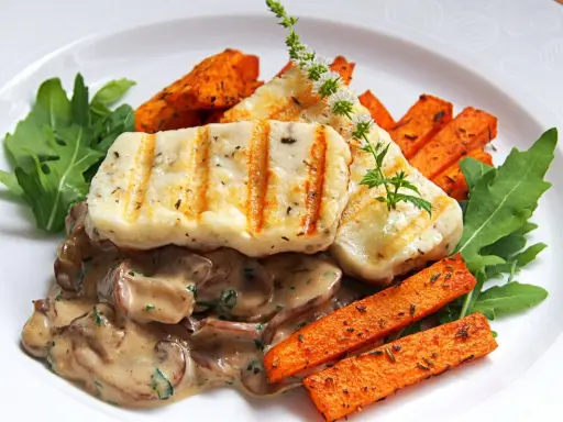 Grillowany ser halloumi z kremowym sosem grzybowym, pieczonymi batatami i rukolą.