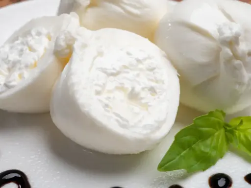 Świeża burrata co to? Delikatny ser z kremowym wnętrzem, podany z bazylią i balsamicznym sosem.