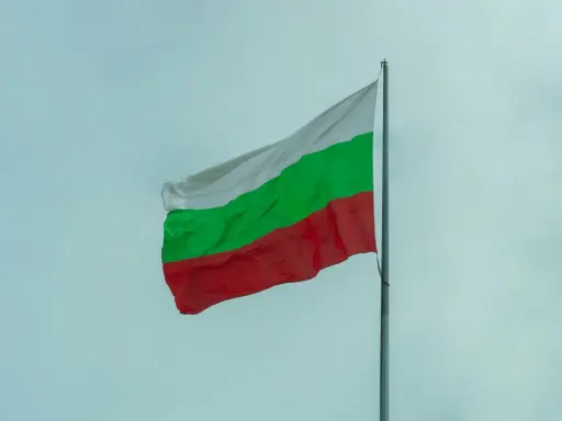 Bułgarska flaga powiewa na tle nieba. Zastanawiasz się nad cenami w Bułgarii?