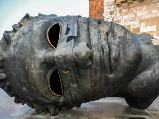 Monumentalna rzeźba głowy na Rynku Głównym w Krakowie. Jedna z wielu ciekawostek o Krakowie, która przyciąga wzrok turystów.
