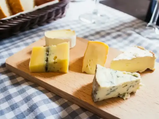 Deska z różnymi rodzajami serów, w tym ser włoski z niebieską pleśnią, idealny na degustację.