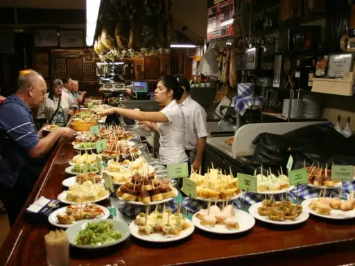 Wybór pysznych tapas na barze, ludzie wybierają przekąski.