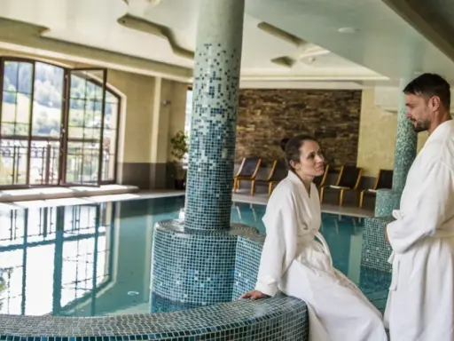 Para w szlafrokach przy basenie. Hotel Elbrus Spa & Wellness – opinie potwierdzają relaks.