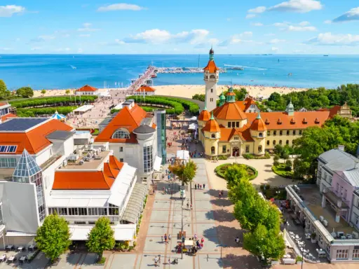 Malownicze miejscowosci nad morzem z molo, plażą i zabytkową architekturą.