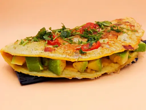 Omlet z awokado, pomidorkami i ziołami, pyszne i zdrowe śniadanie.