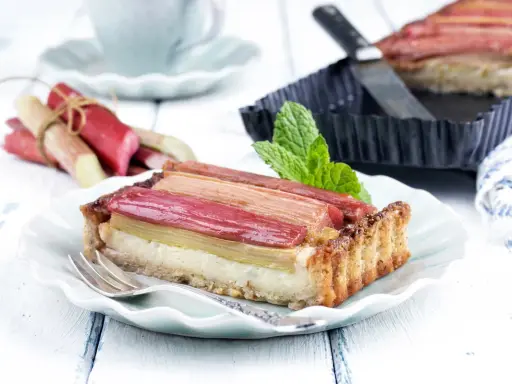 Pyszna tarta z rabarbarem, która pokazuje, co można zrobić z rabarbaru. Podana na talerzyku z widelcem.