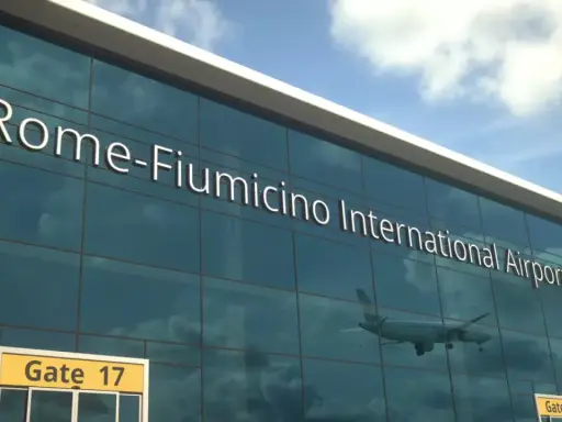 Szklana fasada lotniska Fiumicino w Rzymie, jednego z głównych lotnisk we Włoszech. W odbiciu widać samolot.