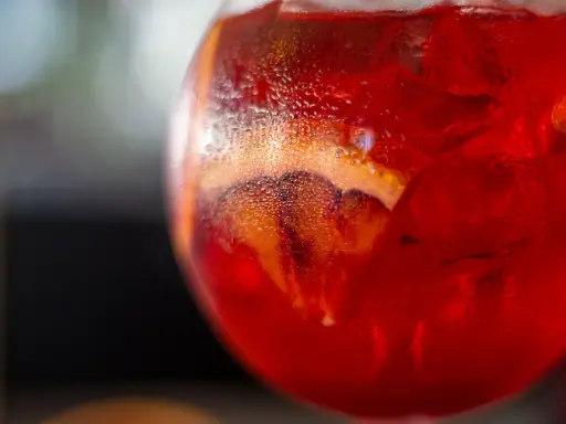Orzeźwiający Martini Fiero drink z lodem i plasterkiem pomarańczy, skraplający się od zimna.