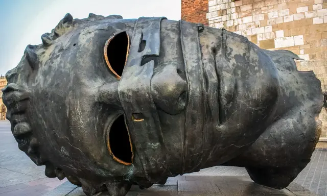 Monumentalna rzeźba głowy na Rynku Głównym w Krakowie. Jedna z wielu ciekawostek o Krakowie, która przyciąga wzrok turystów.